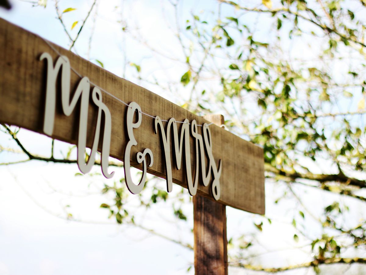 Mr And Mrs Sign Wooden sign hanging from a branch reads Mr and Mrs.
