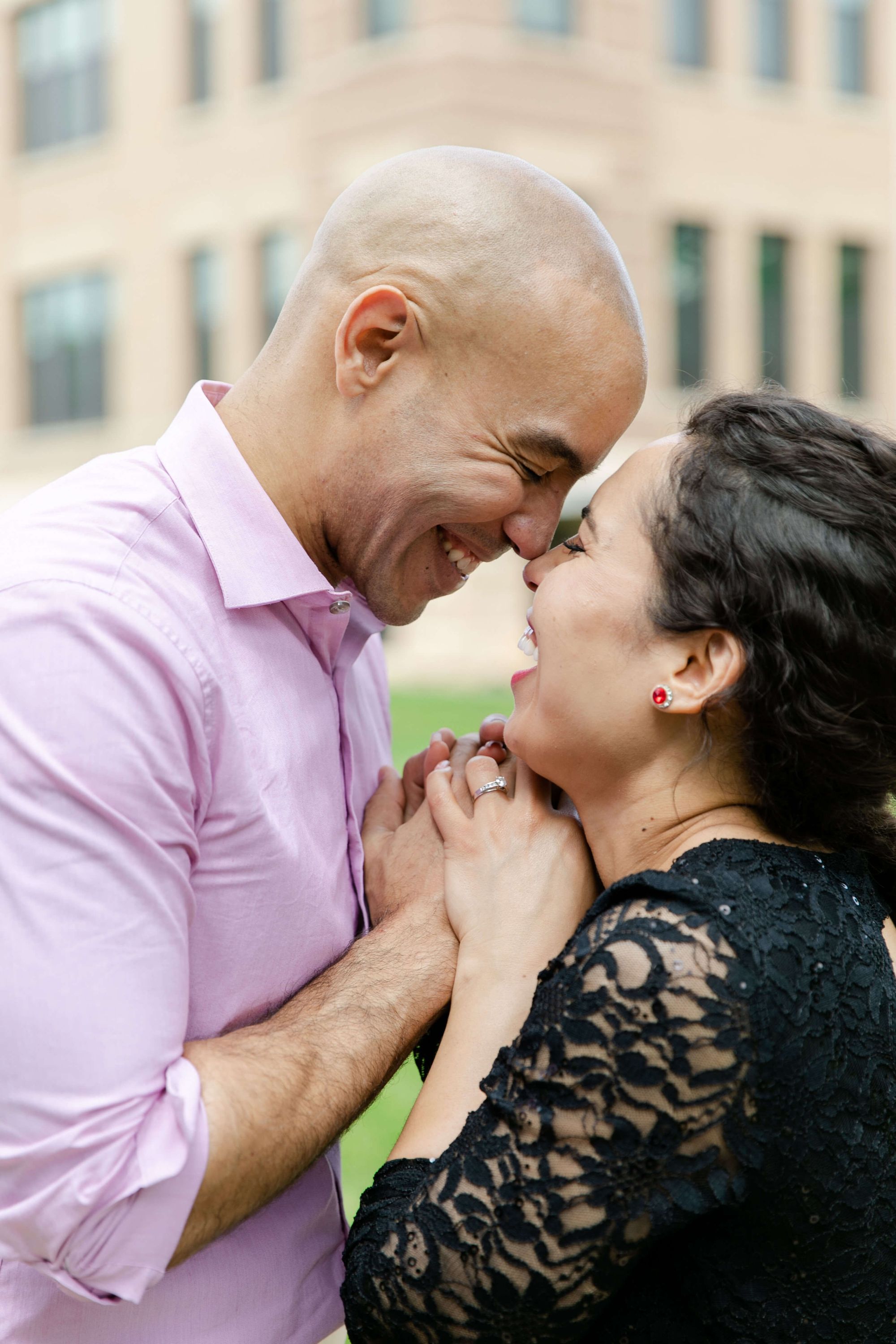 Pink And Black Close portrait of two people facing each other outdoors, one wearing a pink shirt and one a black lace top.