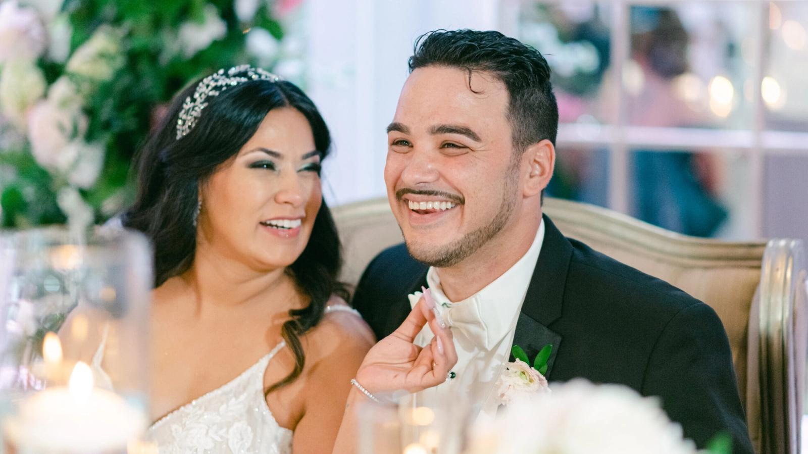 Smiling couple seated together at a table indoors.