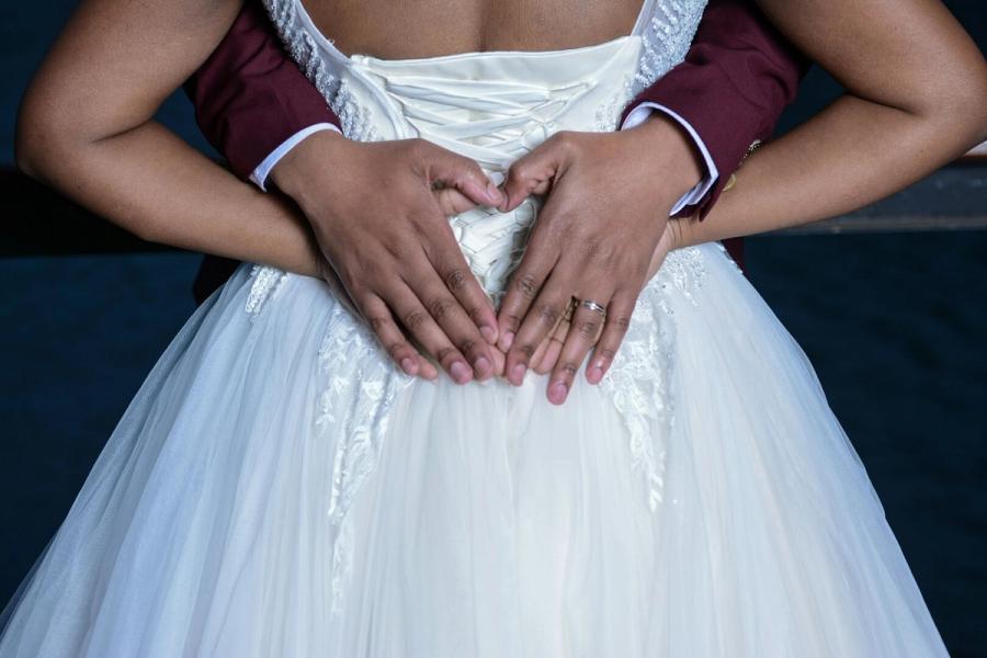 Hand Heart Close crop of two hands forming a heart shape over a white dress.