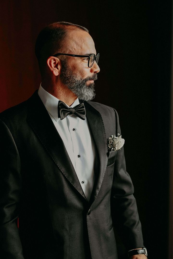 Tuxedo Profile Bearded man in a tuxedo shown in profile against a dark background.