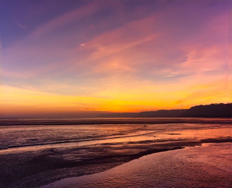 Shoreline Sunset Orange and purple sunset over waves along a shoreline.