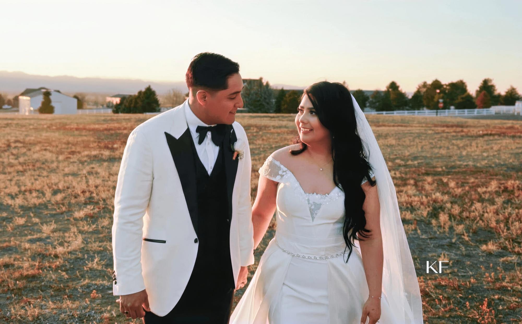 Open Field Walk Person in a white outfit and person in a white jacket walking side by side across an open field.