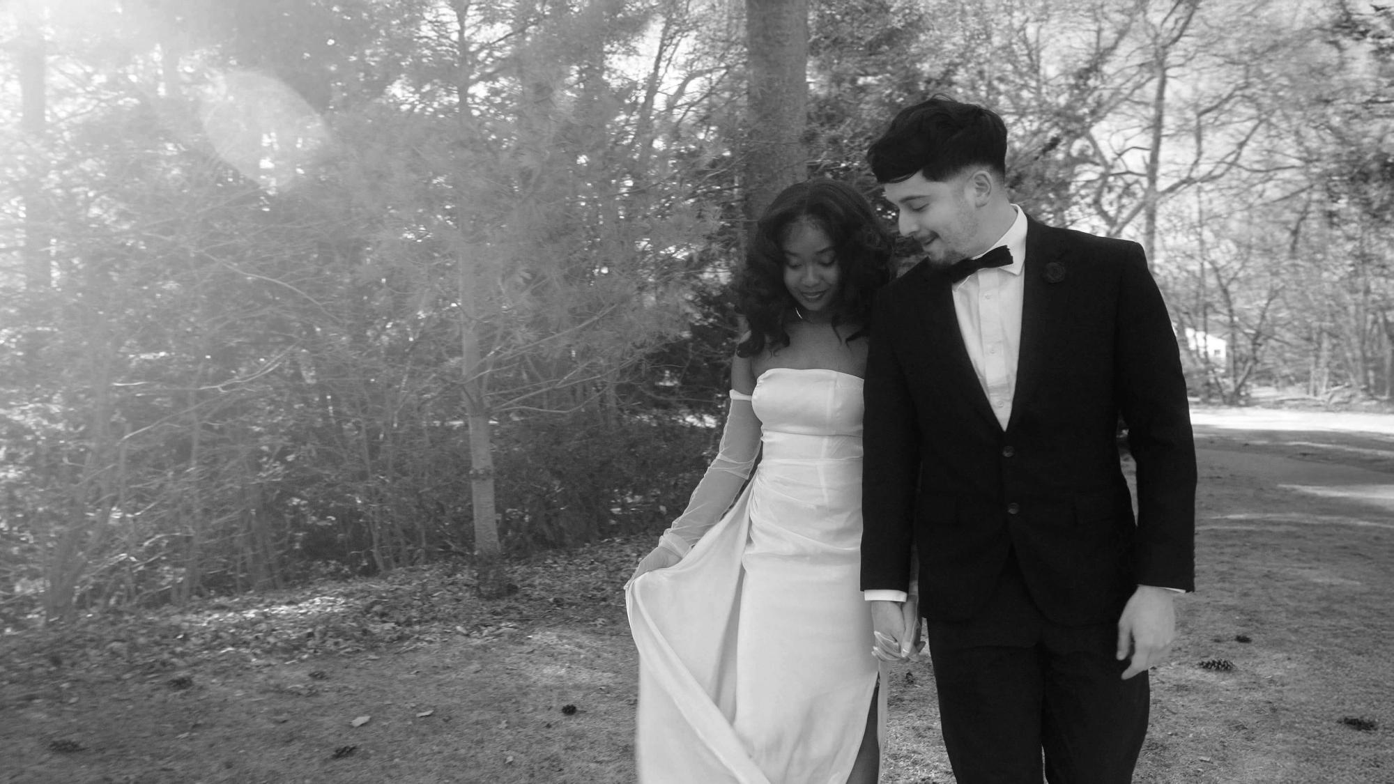 Wooded Walk Black-and-white image of two formally dressed people walking together beneath trees.