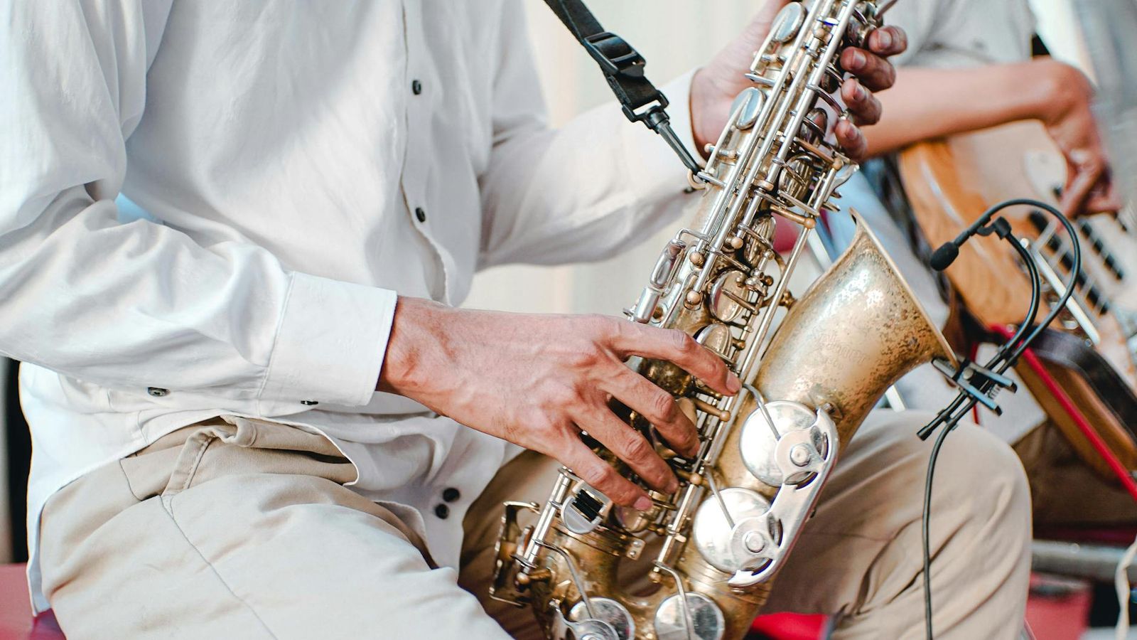 Saxophone Player Close-up of a seated person playing a saxophone.