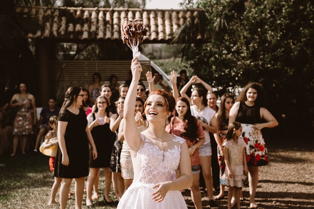 Bouquet Celebration Group of people in formal attire celebrating outdoors as one person raises a bouquet.