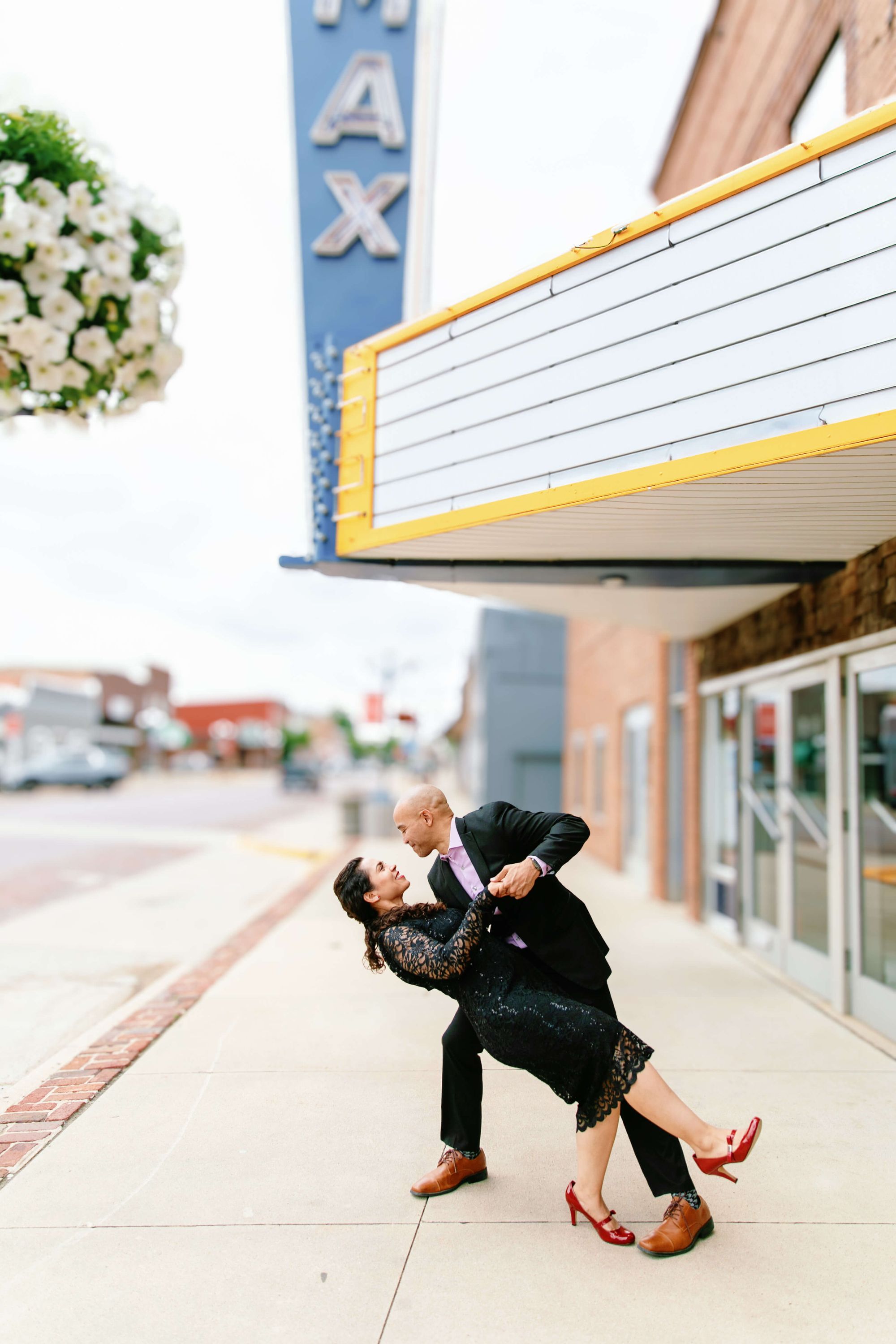 Theater Sidewalk Dip One formally dressed person dips another on a sidewalk beneath a theater marquee.
