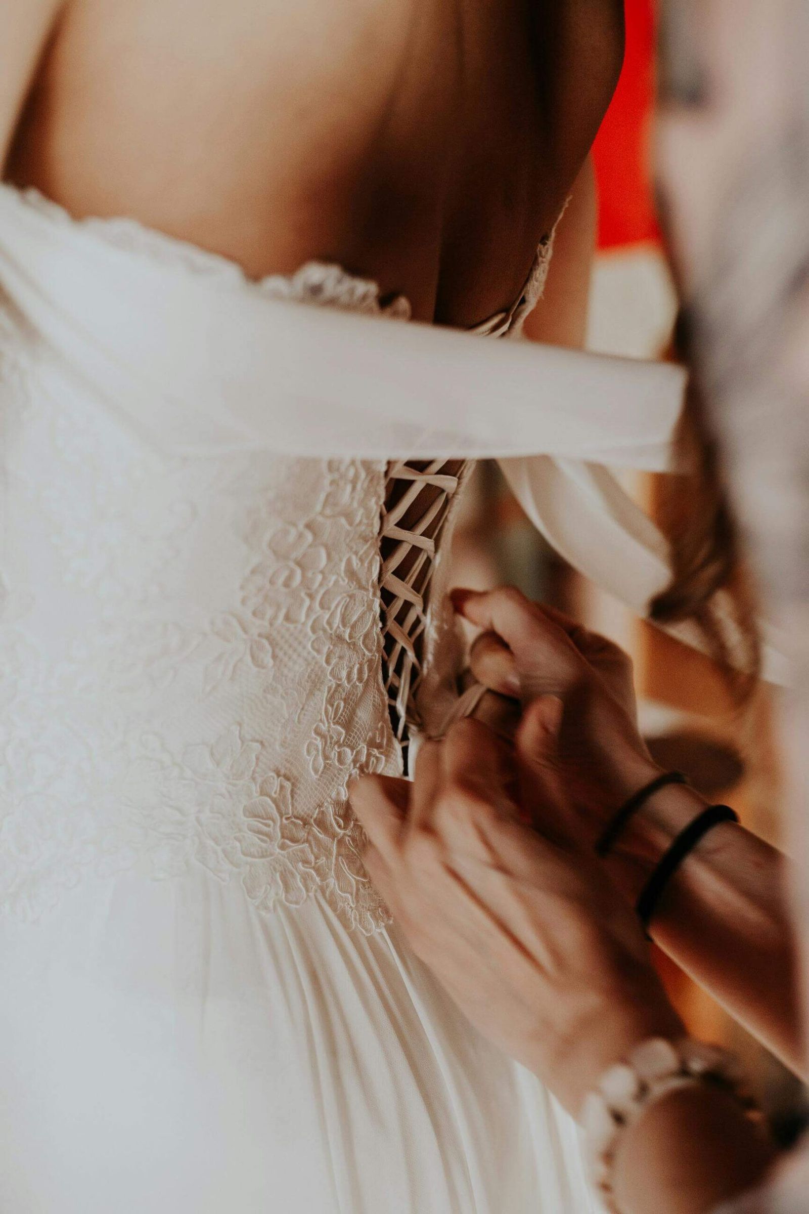 Dress Fastening Close crop of a white lace dress being fastened at the back.