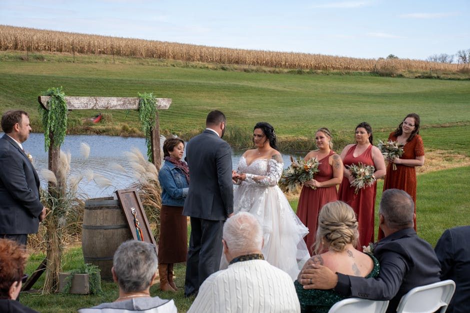 Cornfield Ceremony Outdoor ceremony beside a cornfield with guests seated around a floral arch.