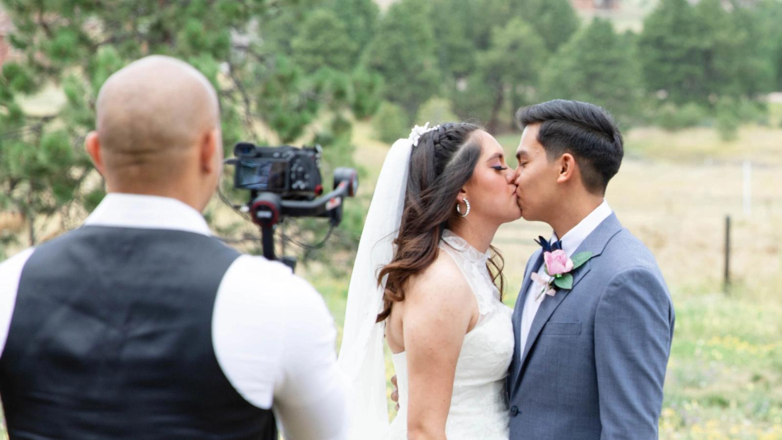 Filming a Kiss Person with a camera filming a couple as they kiss outdoors