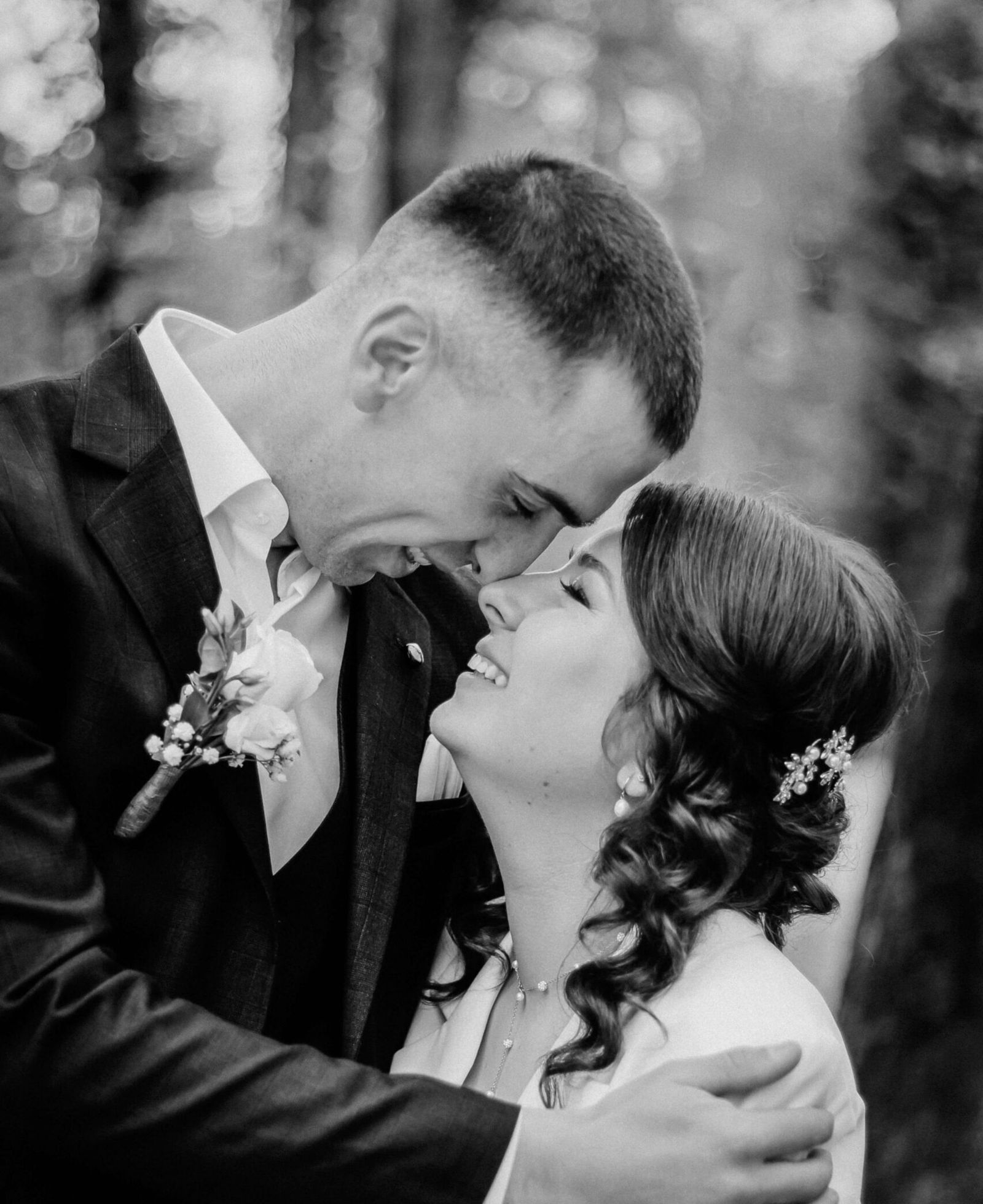 Black-and-white close-up of a wedding couple touching foreheads