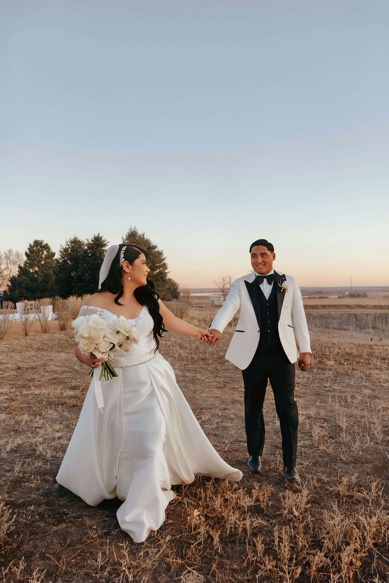 Field Walk Wedding couple walking hand in hand across an open field