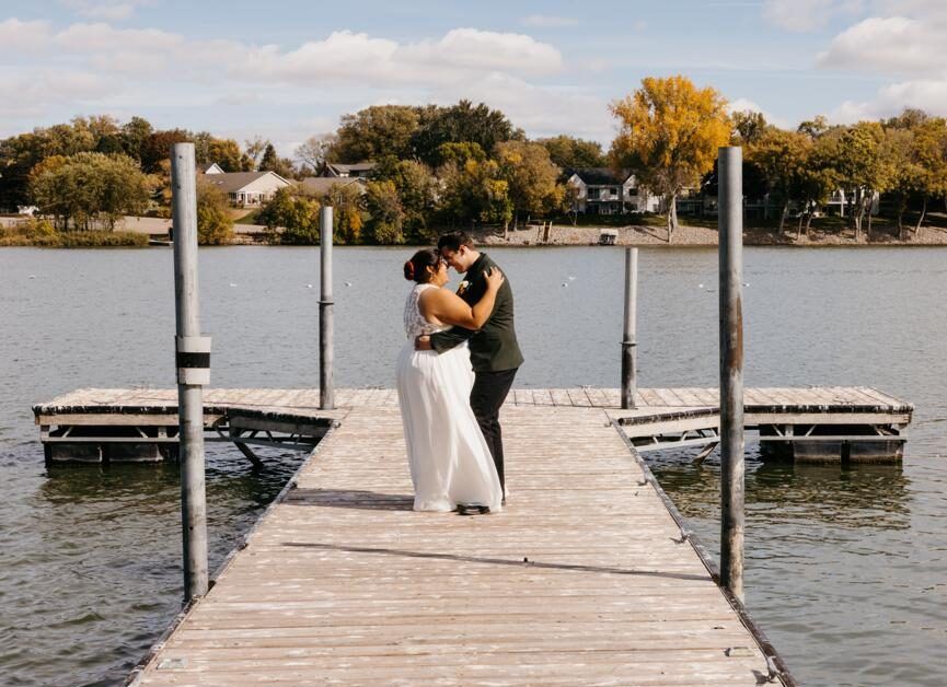 Dockside Embrace Wedding couple embracing on a wooden dock beside water