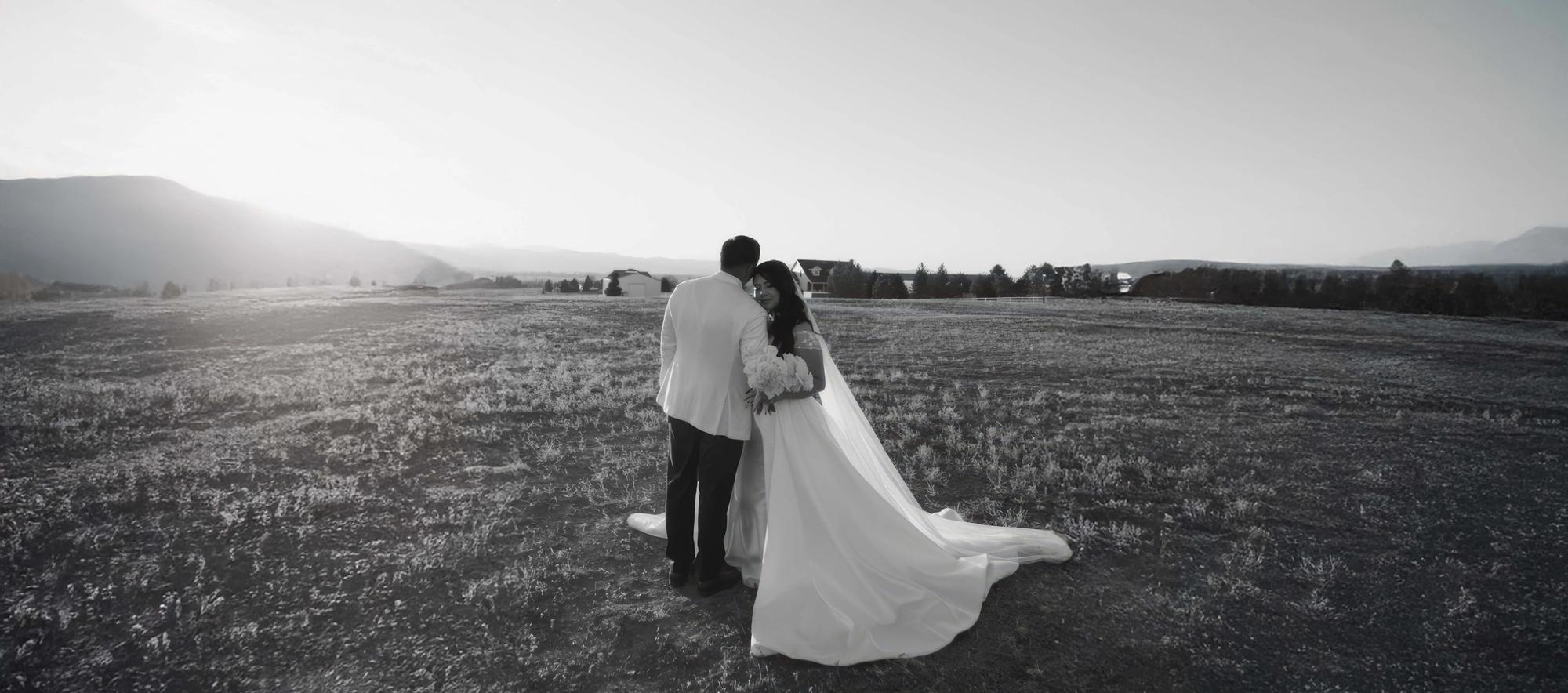 Open Field Rear View Black-and-white rear view of two formally dressed people standing in an open field.