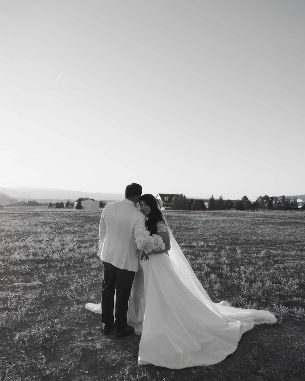 Open Field Rear View Black-and-white rear view of two formally dressed people standing in an open field.