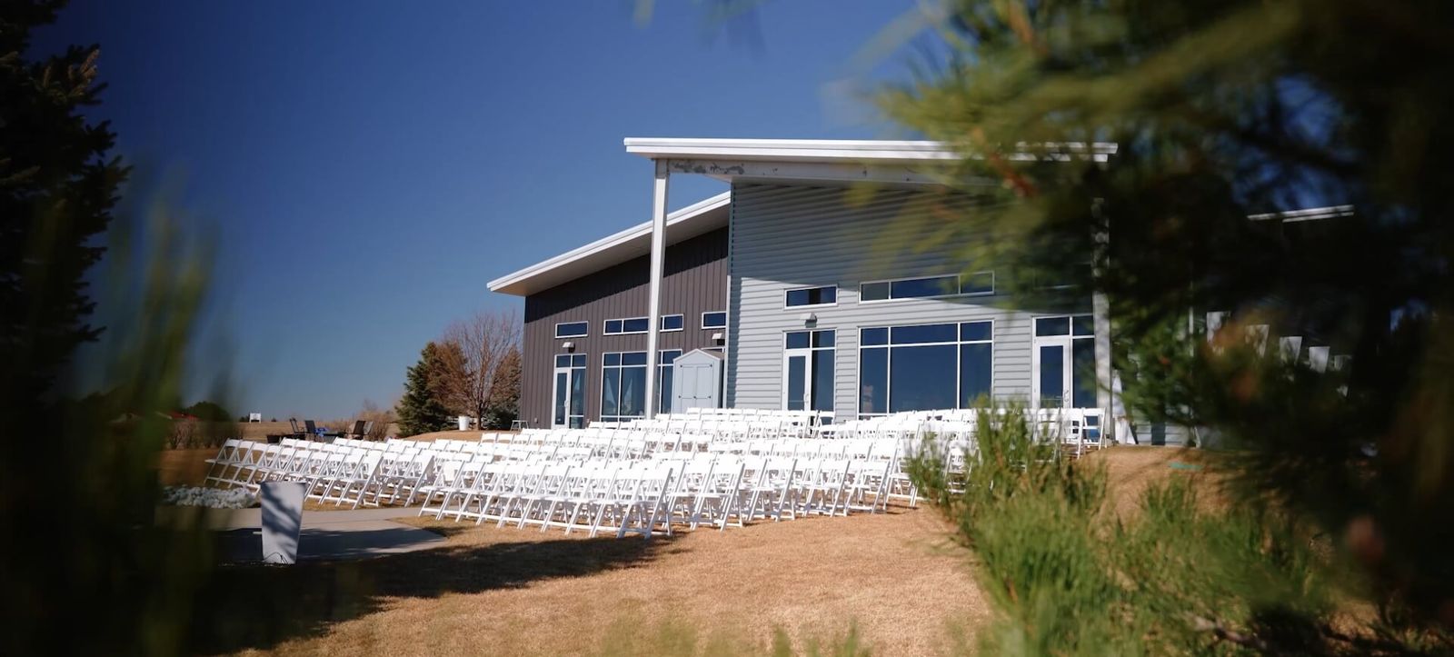 Modern building among grasses beneath a blue sky