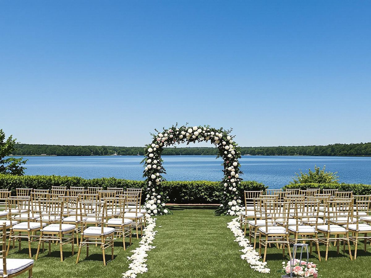 Waterside Floral Arch Outdoor ceremony chairs facing a floral arch beside water