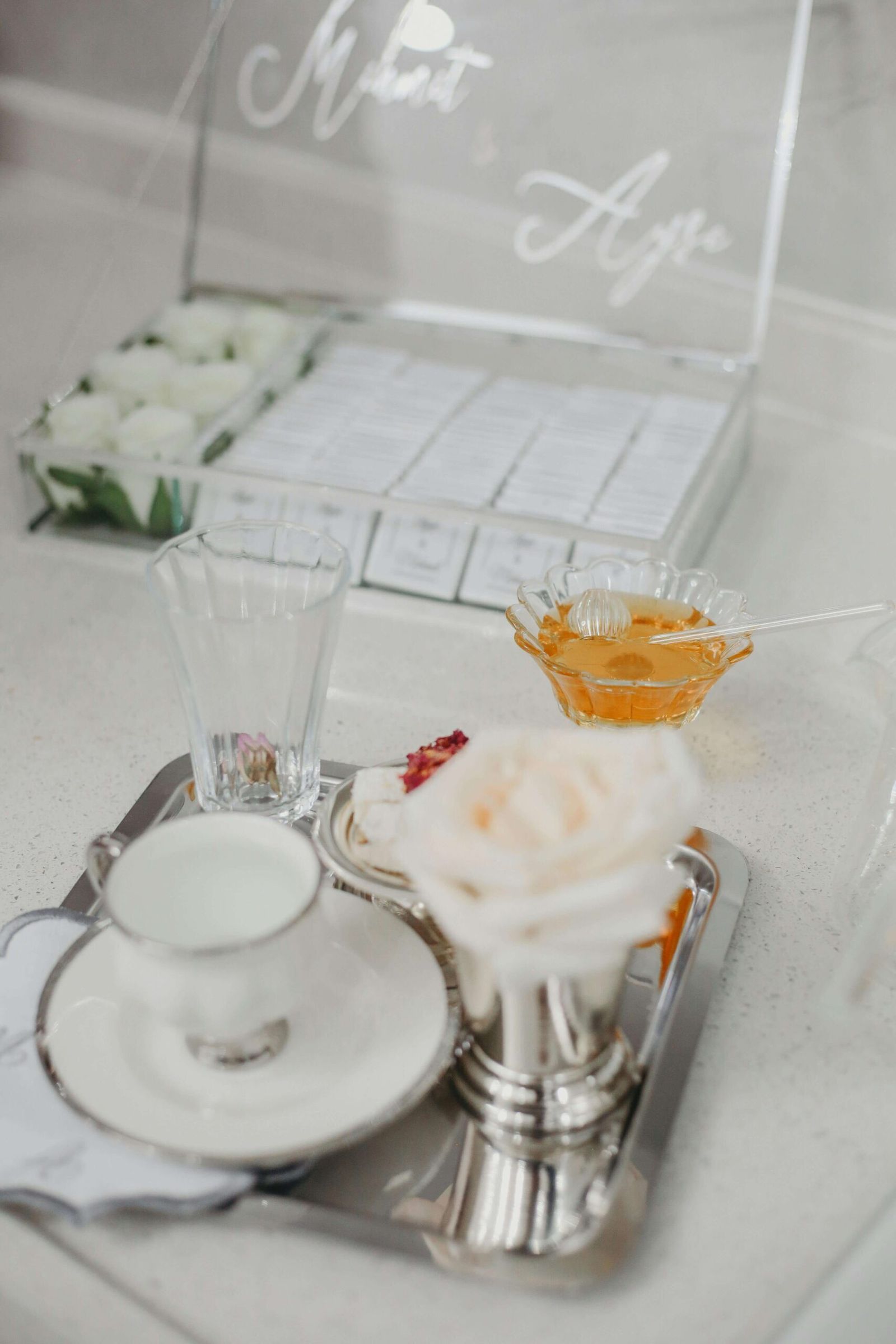 Place setting with white flowers glassware candles and an orange drink