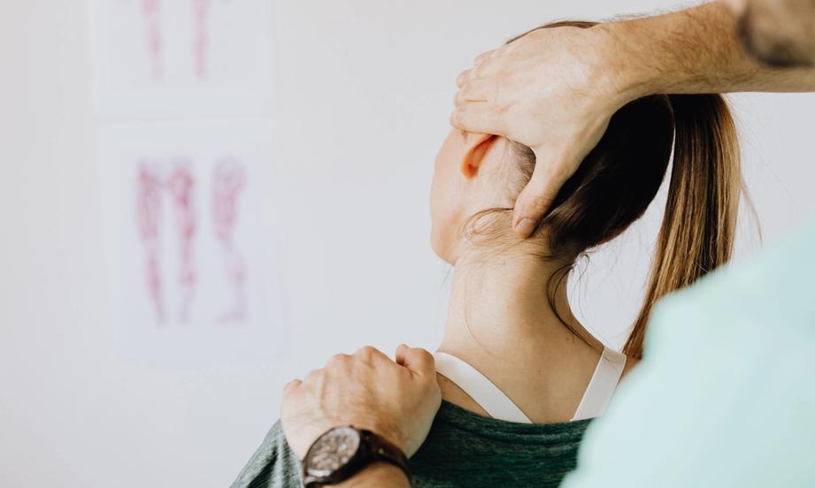 Woman getting her neck assessed for neck pain treatment with chiropractic and physiotherapy in Mesa, AZ
