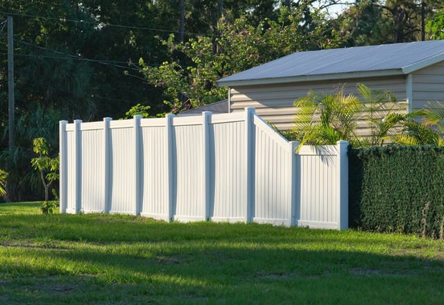 White, plank vinyl fence in a residential area