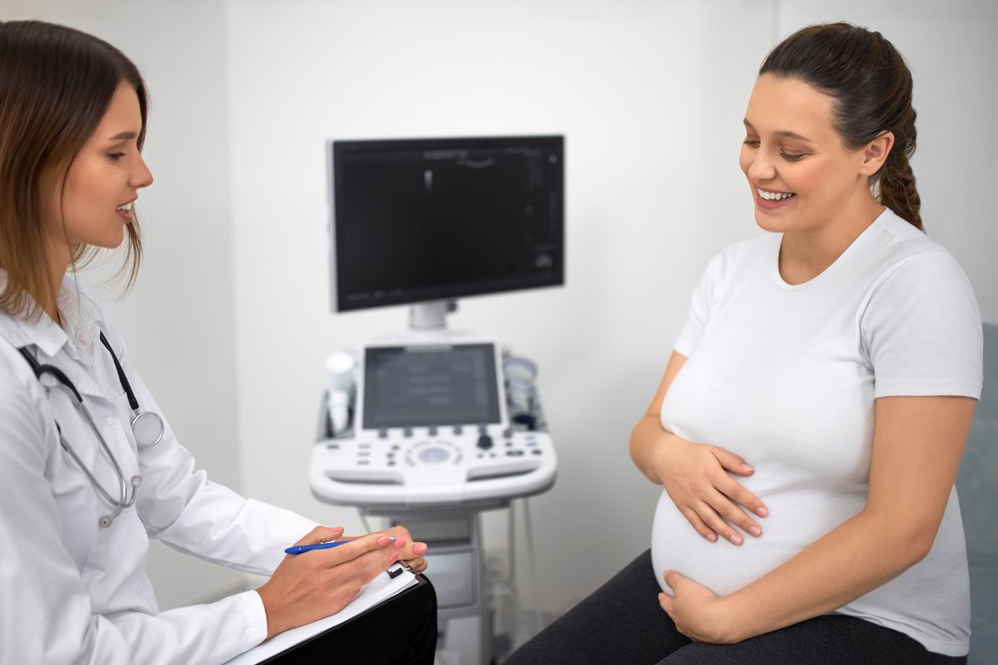 A midwife talks with a pregnant client about their health history.