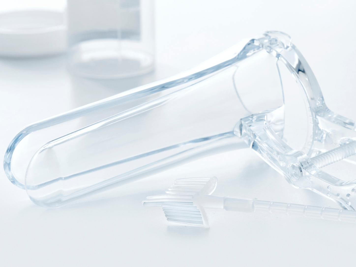 A plastic speculum on a white background.
