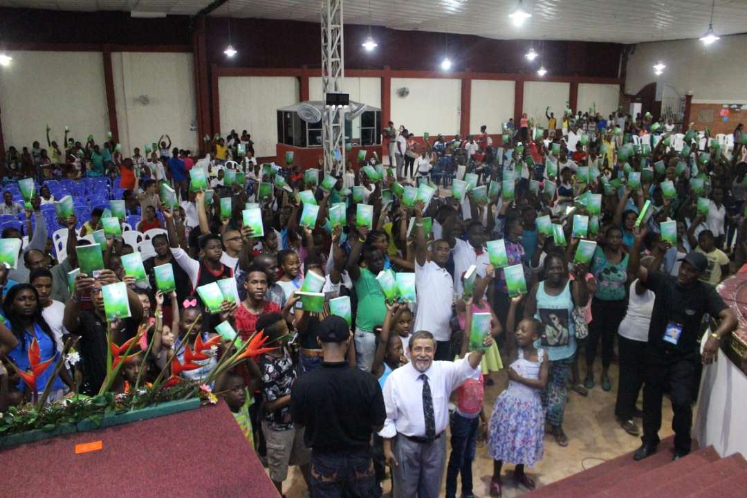 Una multitud levanta Biblias verdes durante un encuentro en Buenaventura