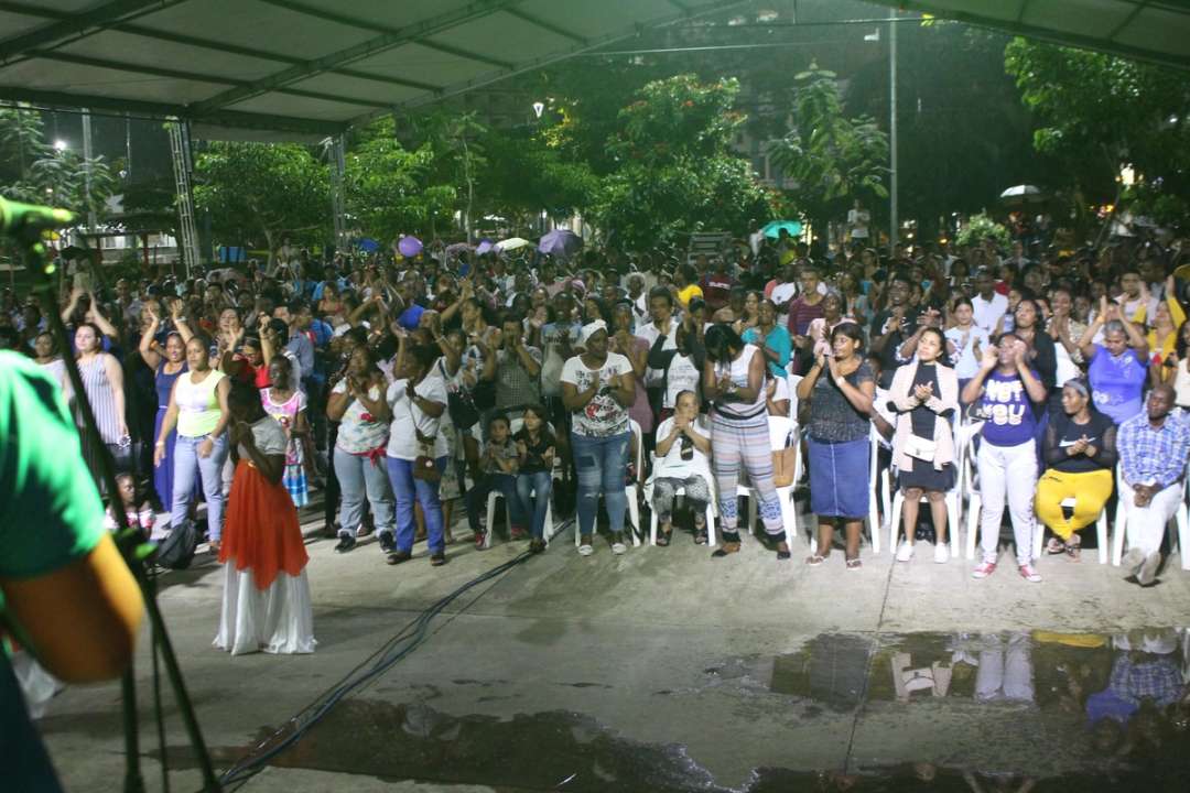 Multitud reunida en un parque iluminado de noche durante la cruzada Explosión