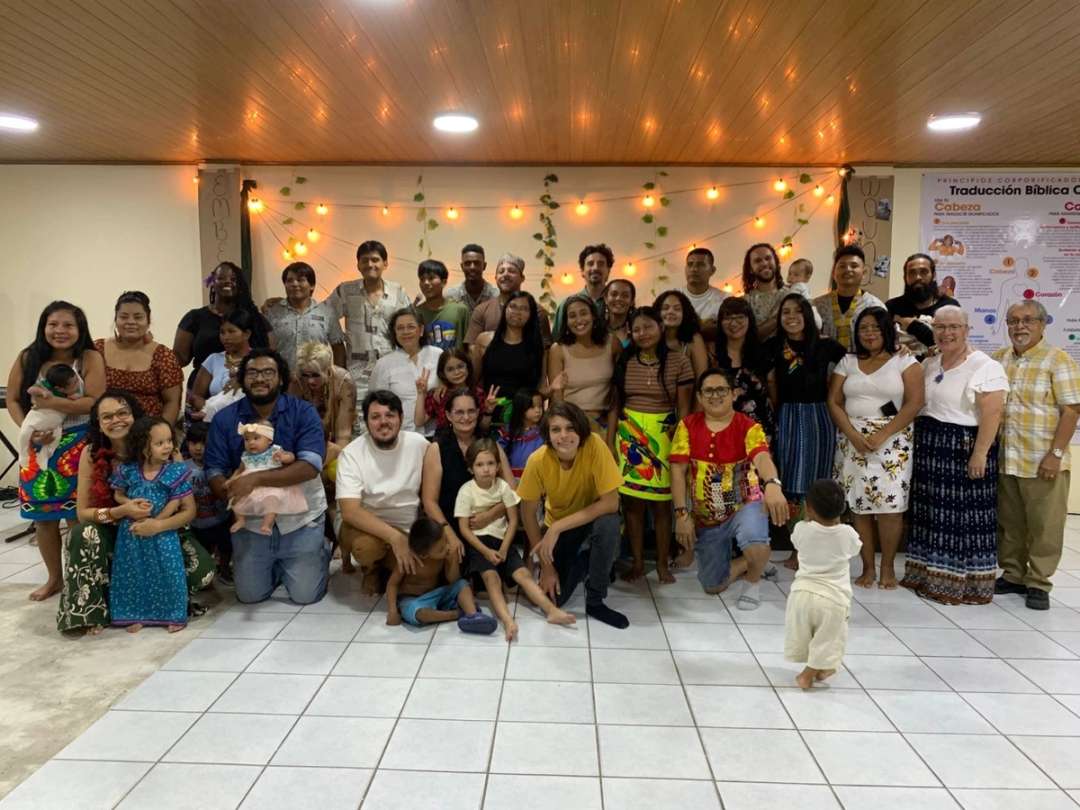 Estudiantes, facilitadores y familias posan juntos en el salón de la escuela