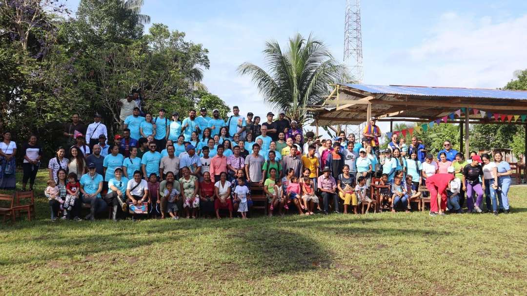 Equipo de JUCUM Leticia con la comunidad indígena reunidos en un gran retrato grupal junto al río