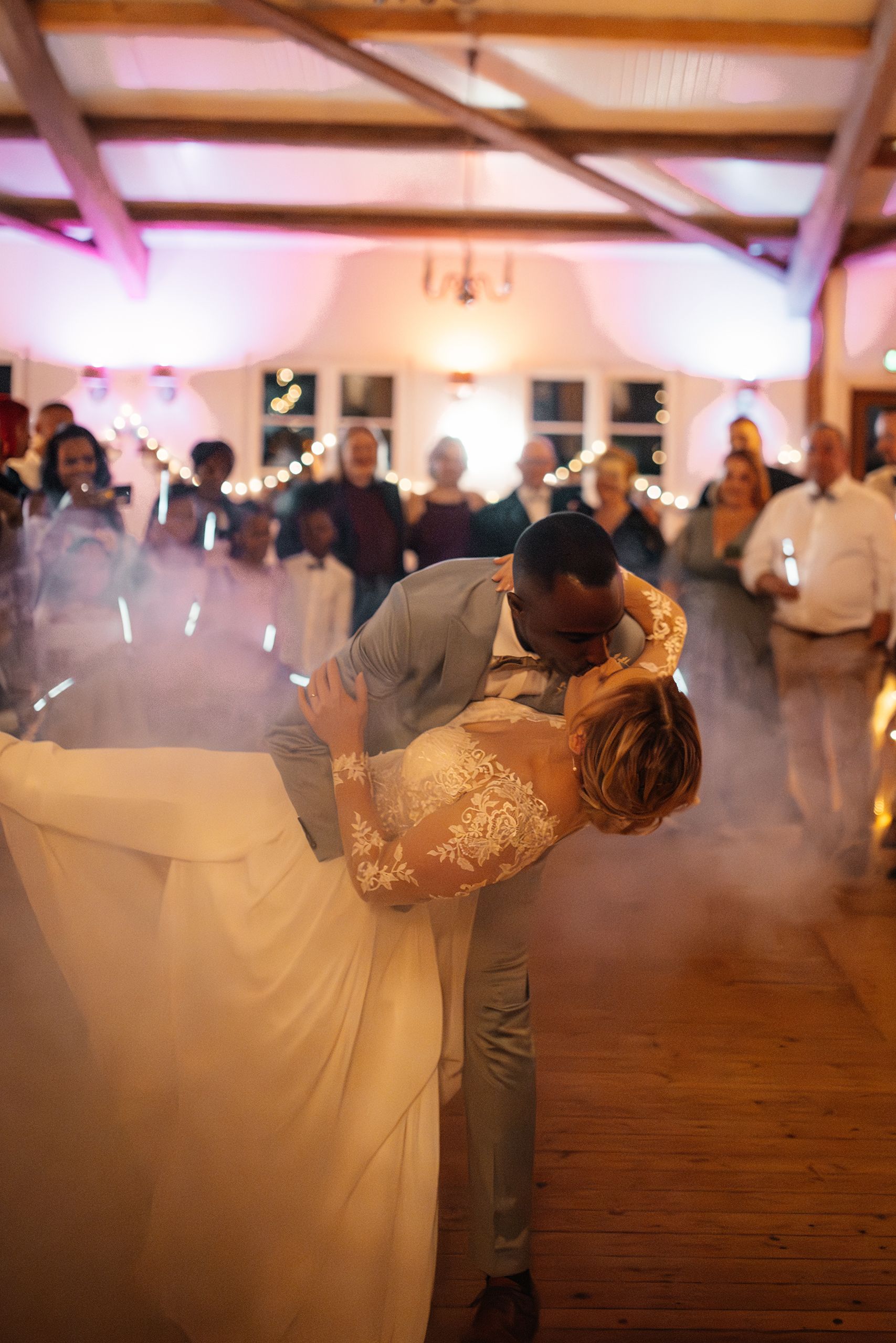 Erster Hochzeitstanz im Trockeneisnebel, die Gäste im Kreis mit Lichtern