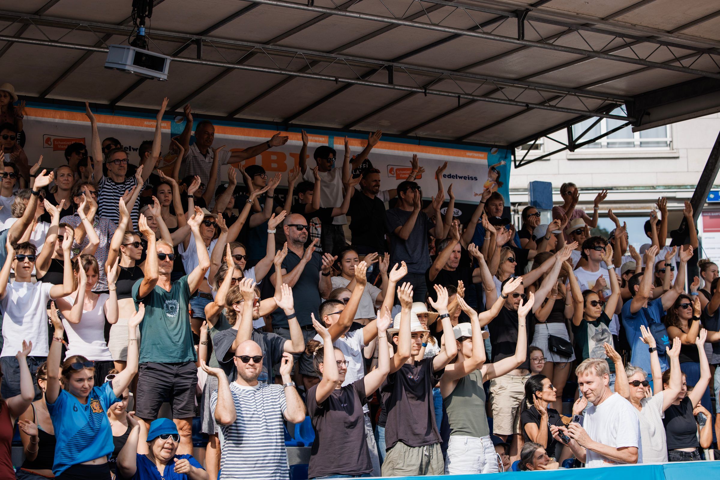 Das Publikum reckt die Arme in die Höhe beim Männerfinale Dillier/Flückiger gegen Breer/Kälin, OBI Beach Tour 2026 auf dem Barfüsserplatz in Basel.