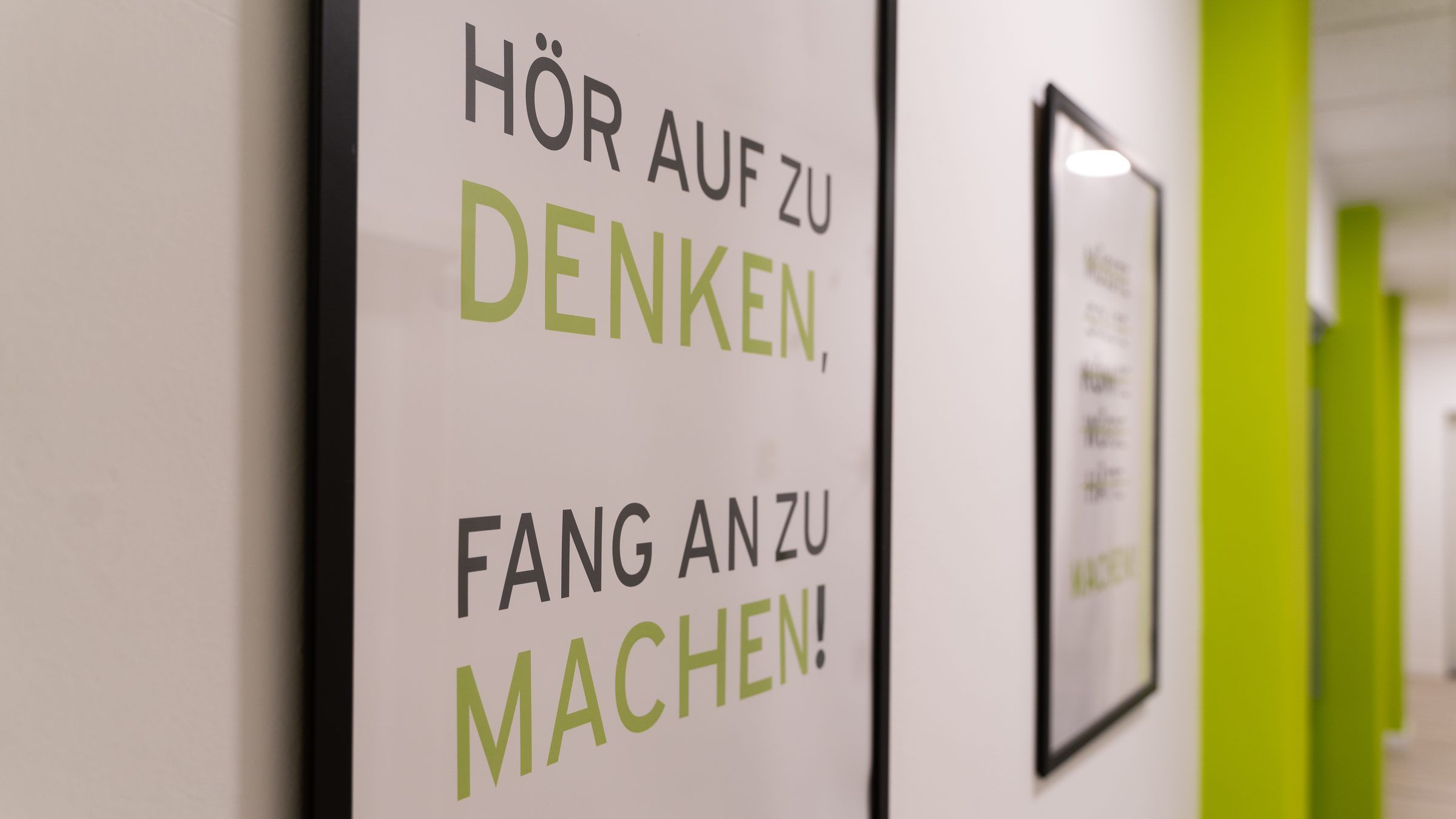 Fensterfolierung mit dem Slogan HÖR AUF ZU DENKEN, FANG AN ZU MACHEN in den Räumen von Image Digital.