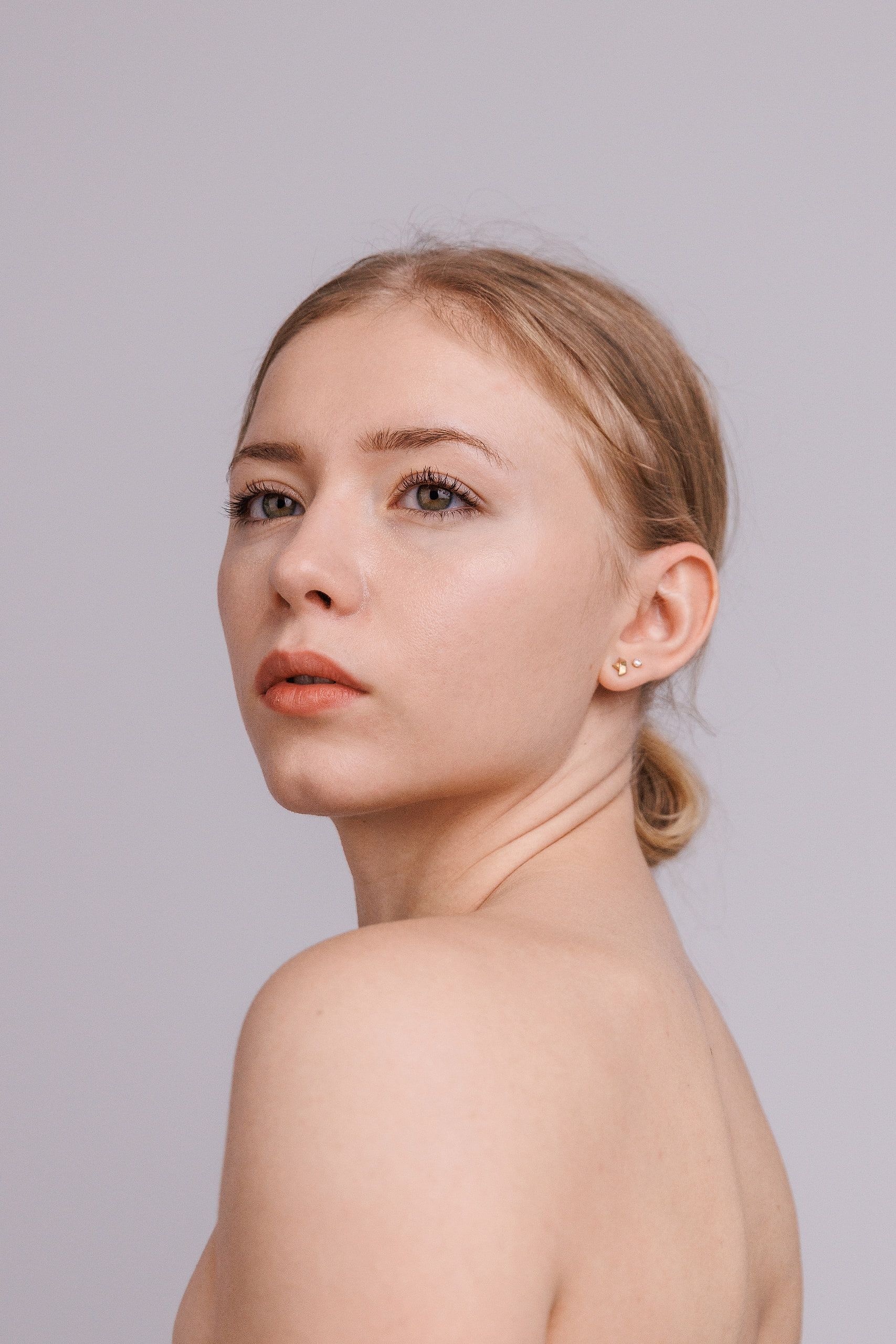 Beauty-Portrait: Annette über die Schulter fotografiert, ruhiger Ausdruck, heller Hintergrund.