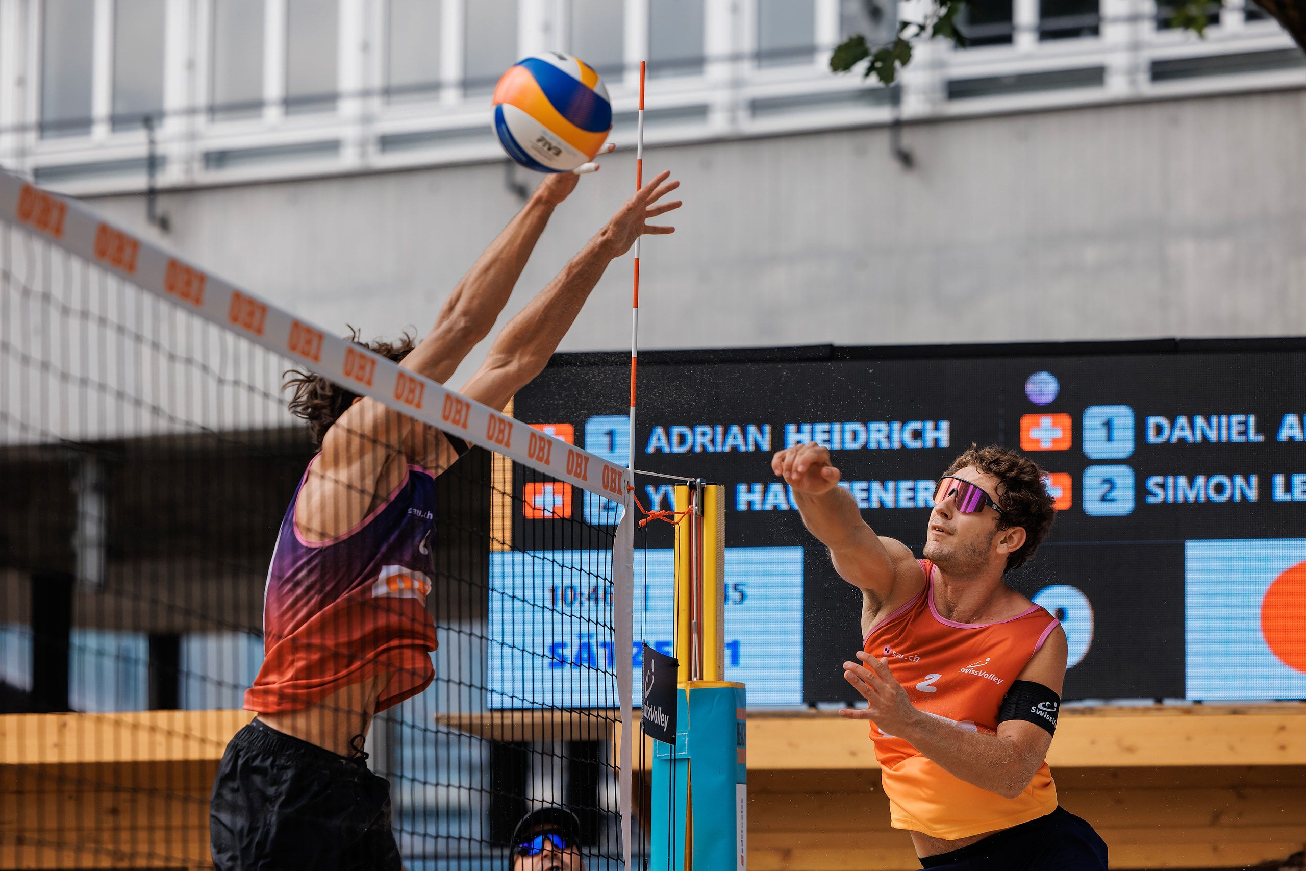Yves Haussener im Angriff gegen den Block von Simon Leffler, im Halbfinale Heidrich/Haussener gegen Allemann/Leffler bei der OBI Beach Tour 2026 in Luzern.