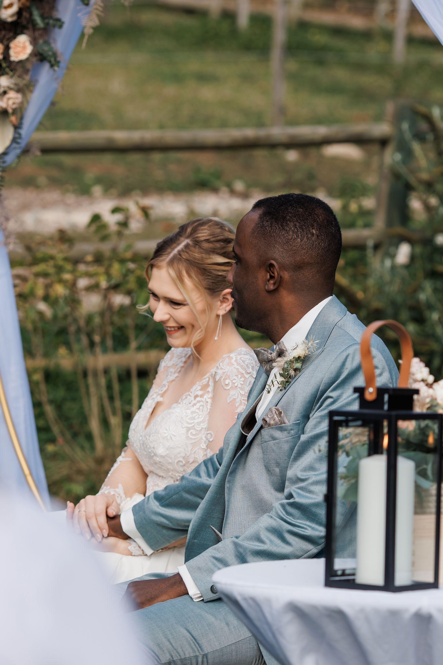 Katharina und Ali Hand in Hand während der freien Trauung, daneben die Kerzenlaterne