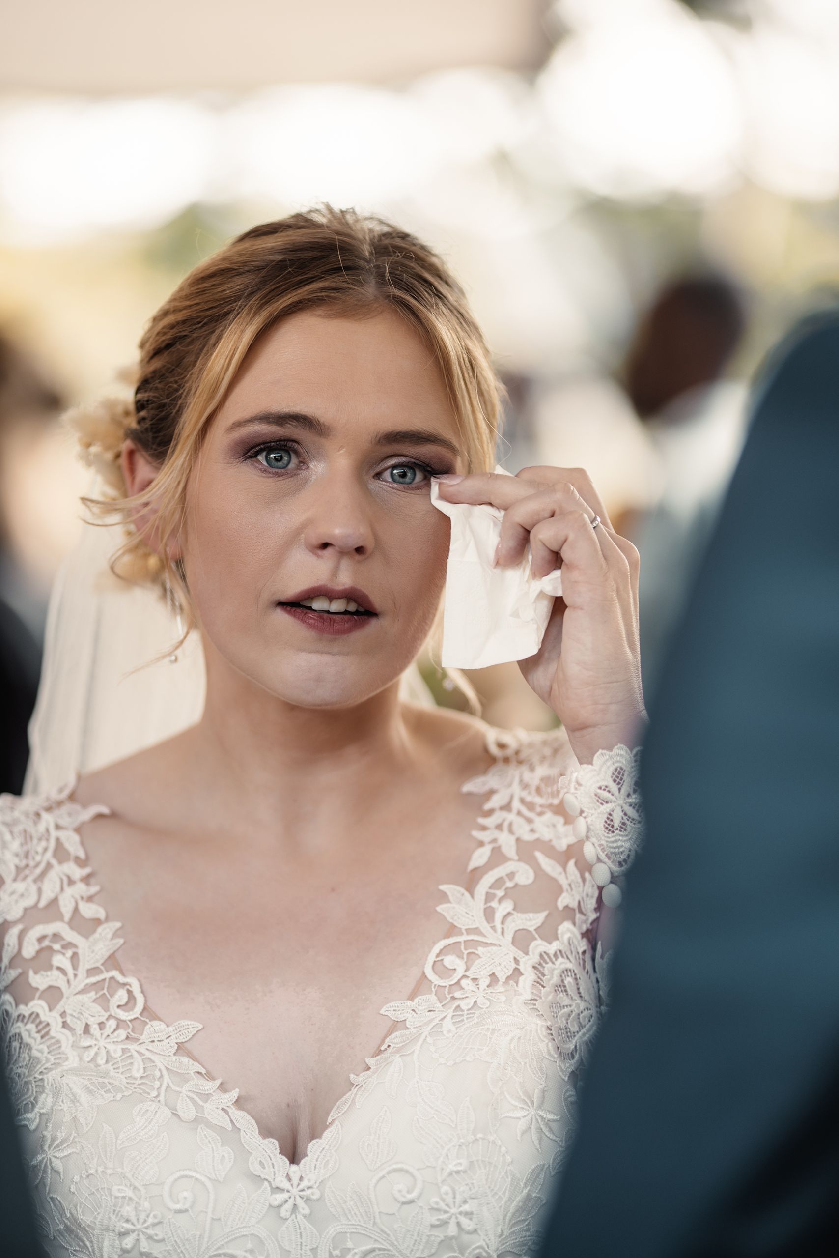 Katharina wischt sich während der freien Trauung eine Träne aus dem Auge