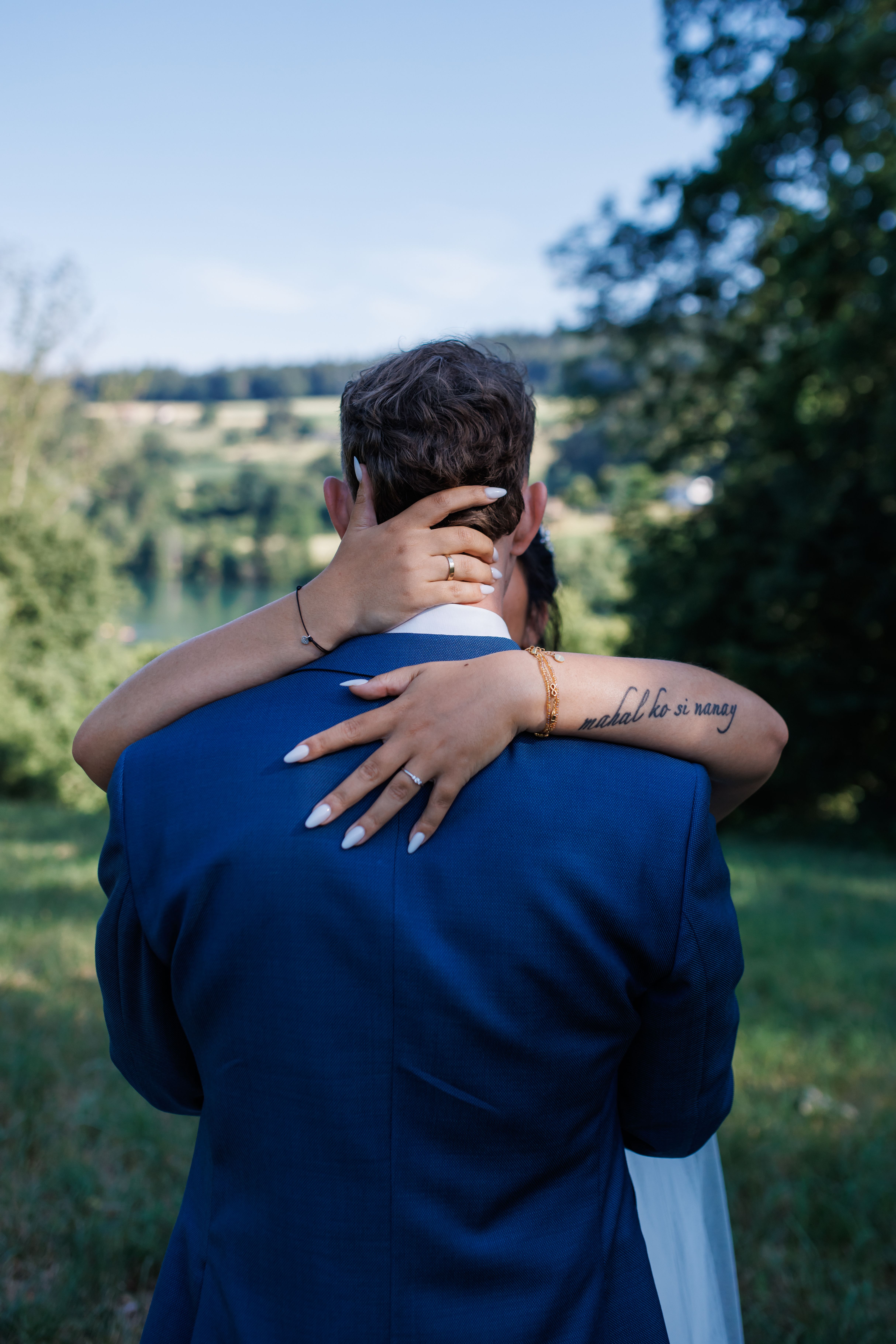 Stefanie umarmt Manuel von hinten, ihr Arm mit Tattoo liegt um seinen Hals