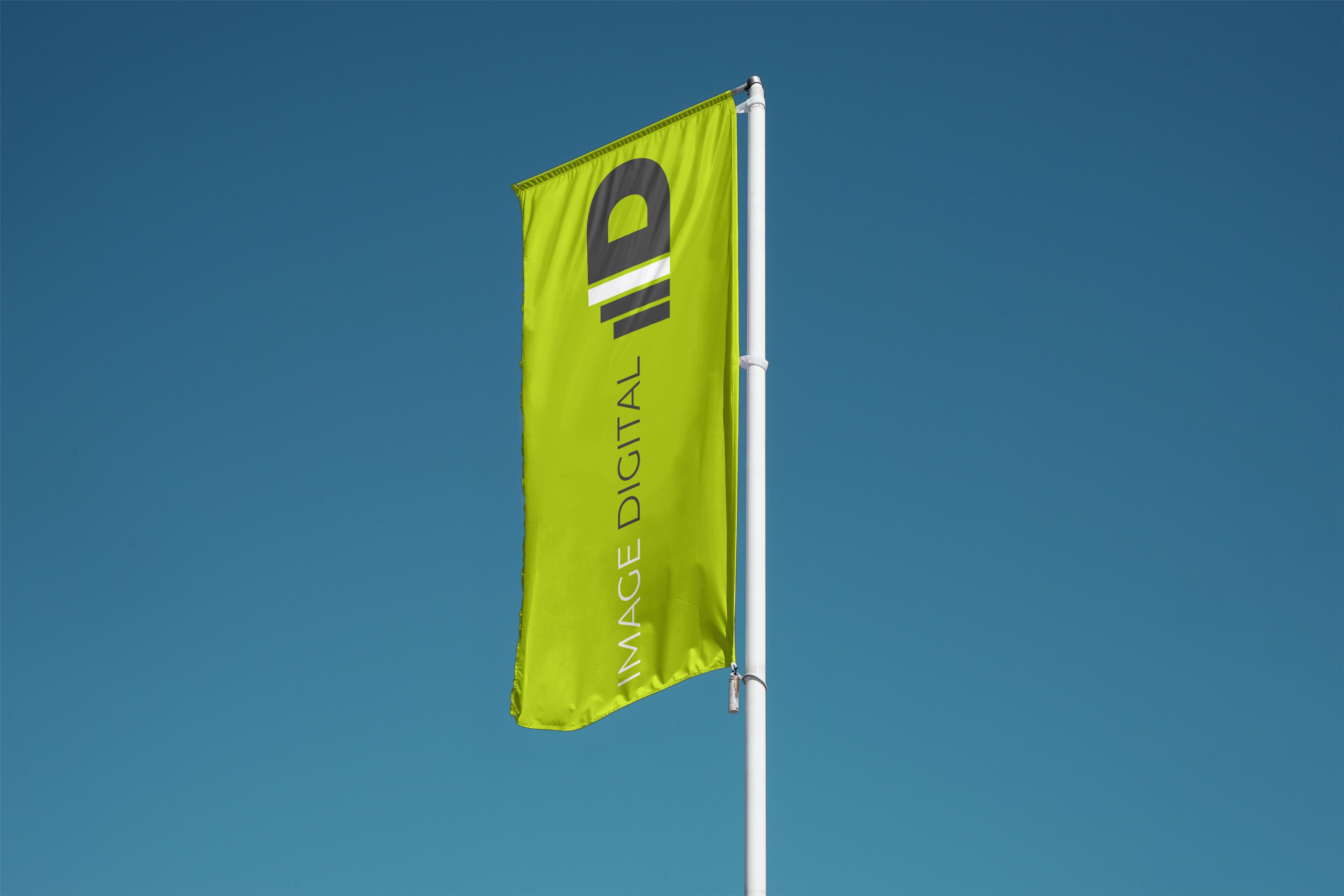 Grüne Image-Digital-Fahne mit dem ID-Signet vor blauem Himmel.