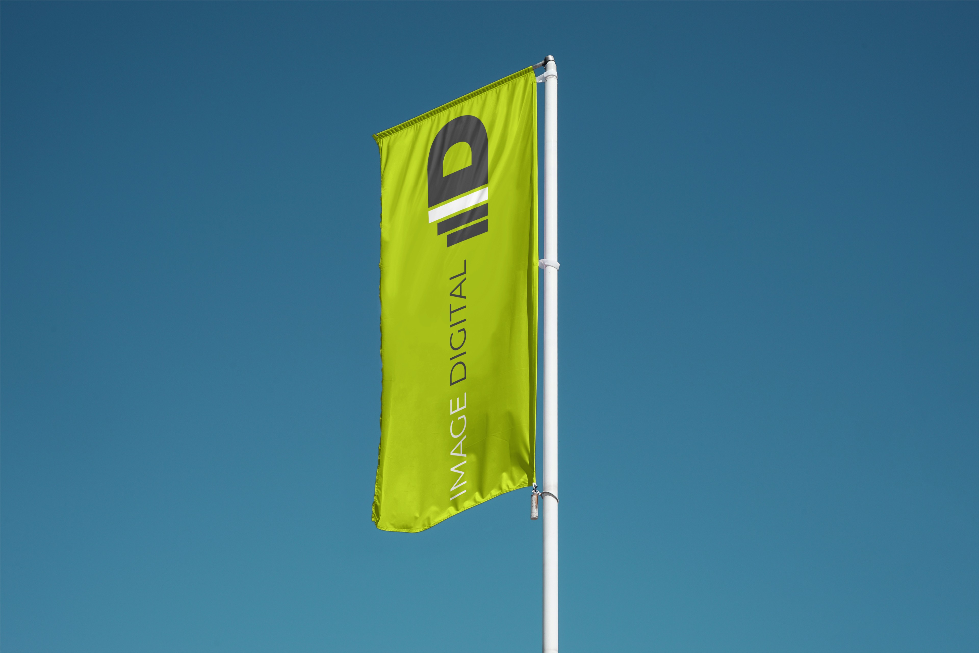 Grüne Image-Digital-Fahne mit dem ID-Signet vor blauem Himmel.