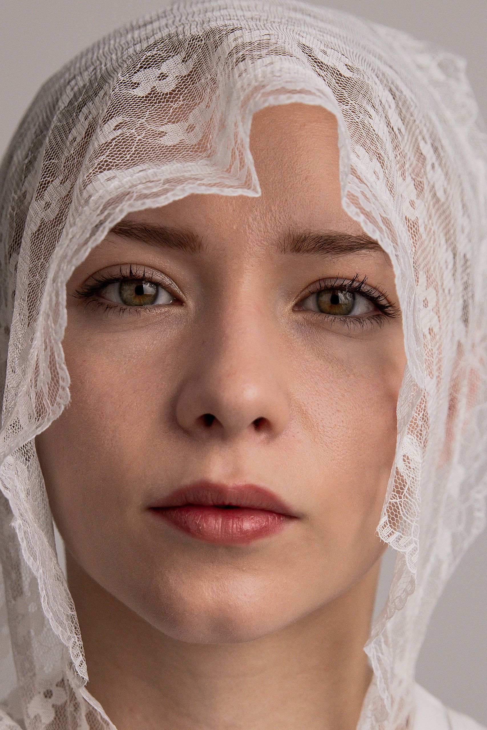 Beauty-Portrait: Annette mit einem Spitzenschleier über dem Haar, direkter Blick in die Kamera.