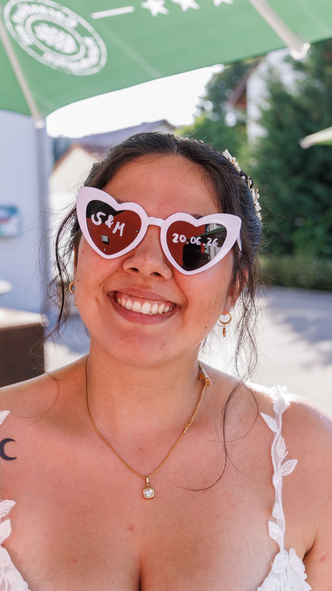 Stefanie mit weißer Herzchen-Sonnenbrille, auf den Gläsern die Initialen S und M sowie das Hochzeitsdatum 20.06.26