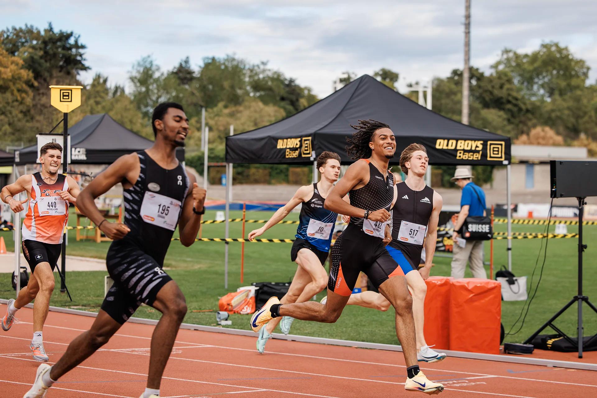 Sprintlauf mit den Startnummern 12, 195, 542, 440, 517, 10 und 482 bei den Schweizer Meisterschaften U20/U23 2026 im Stadion Schützenmatte in Basel.