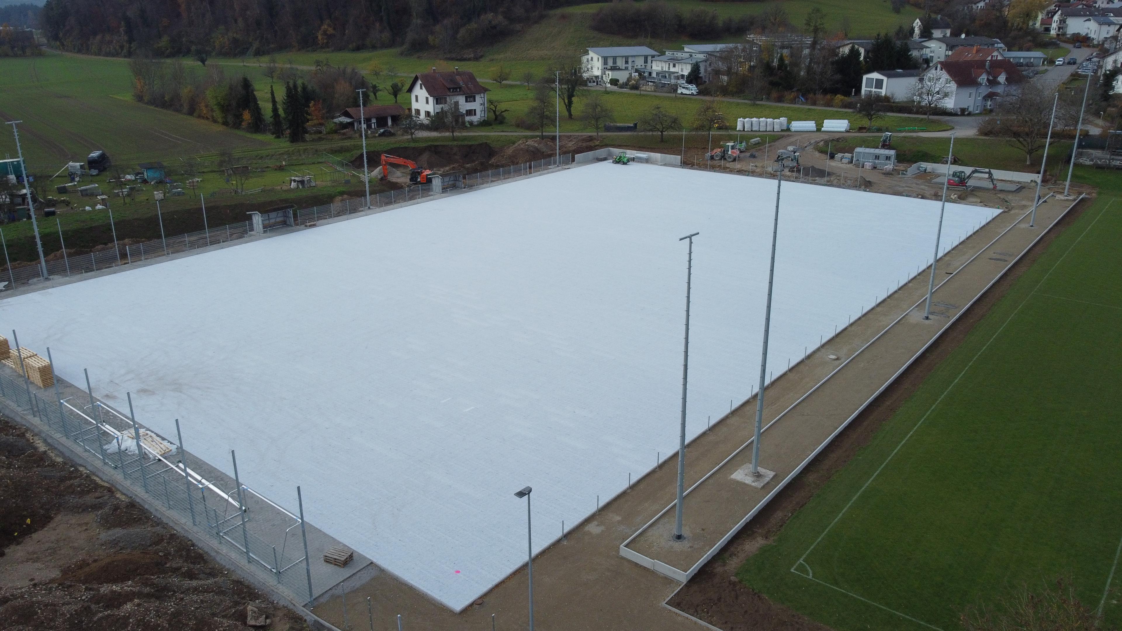 Schrägluftbild des neuen Kunstrasen-Untergrunds beim VfR Horheim-Schwerzen mit Baumaschinen und angrenzendem Rasenplatz, Drohnenaufnahme von aLx-design