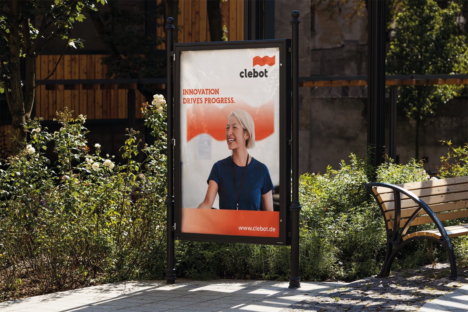 Clebot Citylight-Plakat „Innovation drives progress" an einer Bushaltestelle bei Tag.