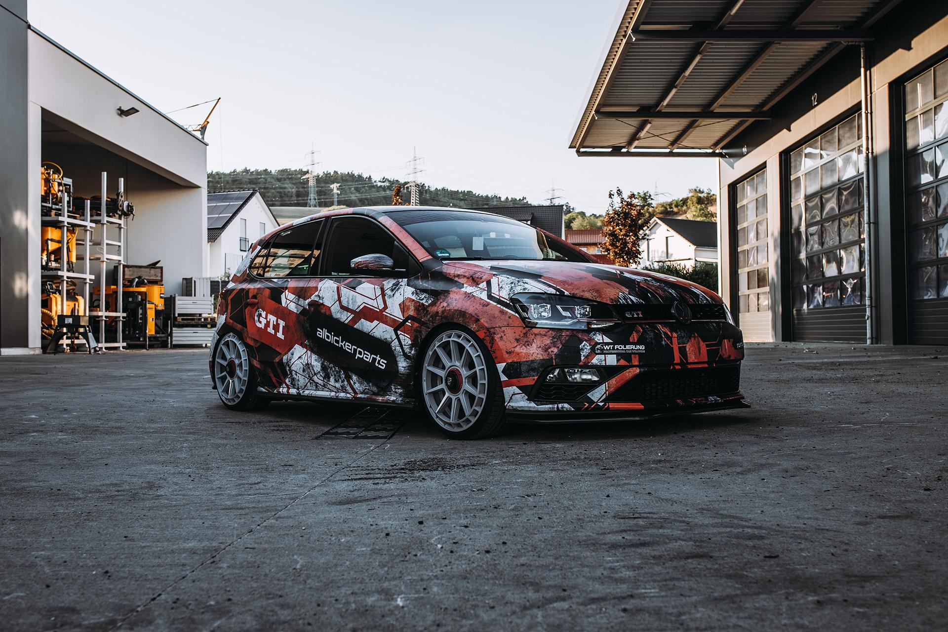 Vollfolierter VW Polo GTI in Schwarz, Rot und Weiß vor Gewerbehallen im Hochschwarzwald