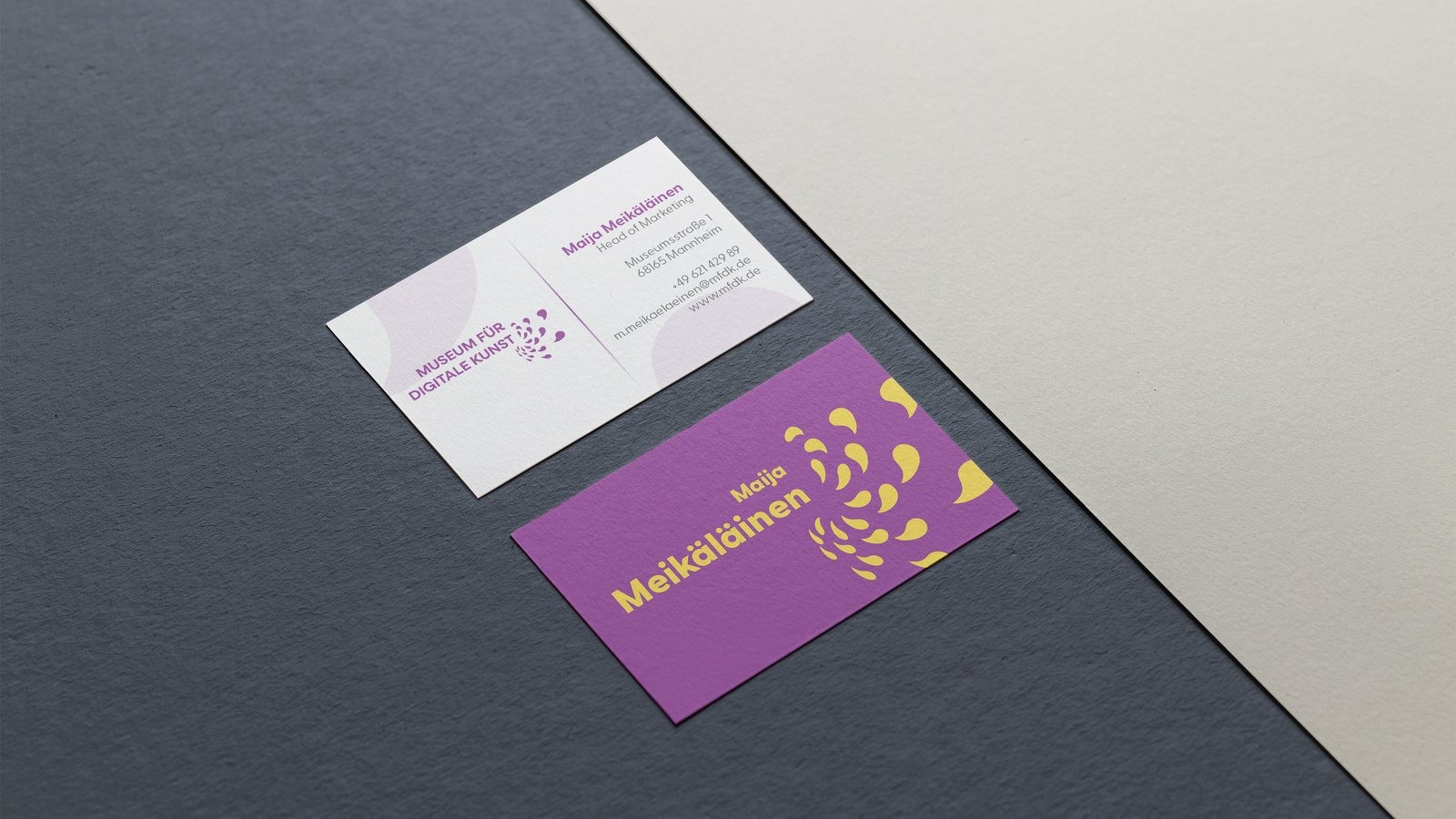 Visitenkarten des Museums für digitale Kunst (MFDK) als Mockup: die Schwarm-Marke in Violett und Gelb.