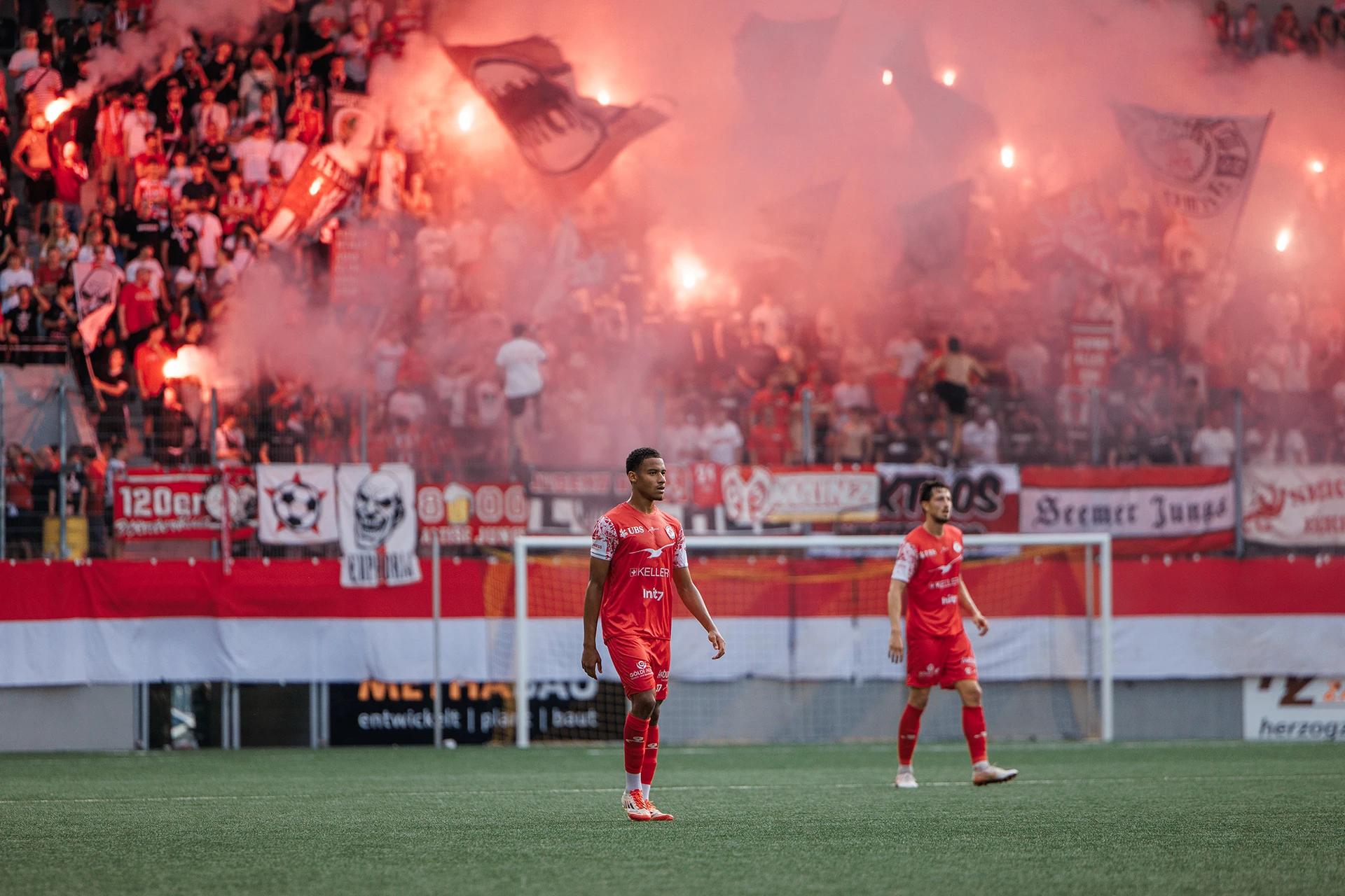FC Winterthur spieler vor dem Gästeblock mit Pyrotechnik