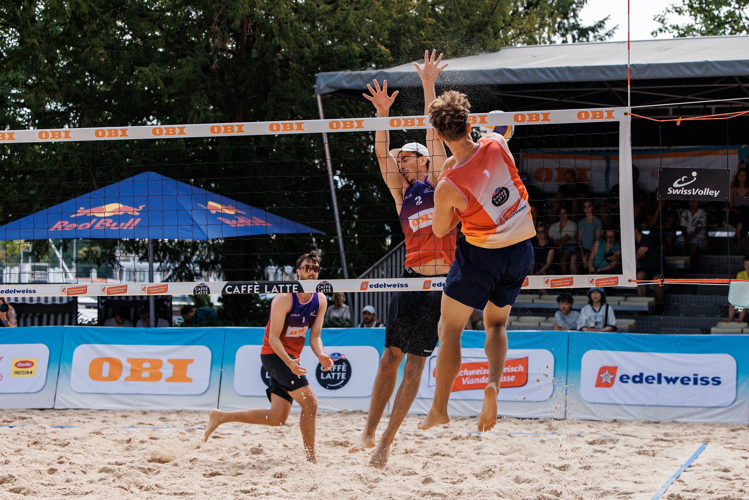 Florian Breer im Angriff gegen den Block von Célian Métral, im Spiel Métral/Métral gegen Breer/Kälin bei der OBI Beach Tour 2026 in Luzern.
