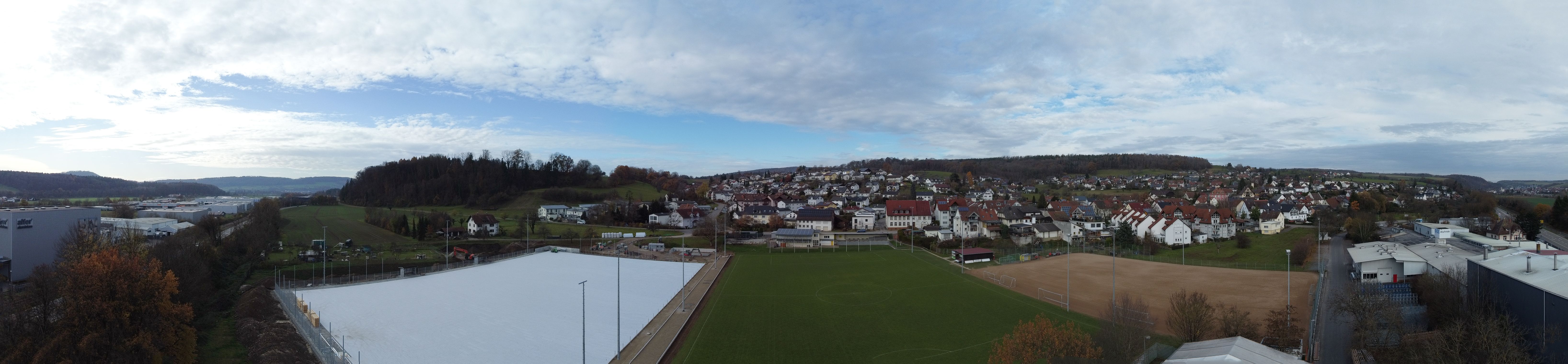 Weitwinkel-Panorama des VfR-Sportgeländes aus der Luft mit dem neuen Kunstrasen-Untergrund, dem bestehenden Rasenplatz und dem Ort Horheim